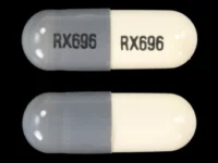Pill with imprint RX696, gray & white, capsule, 18 mm (Minocycline Hydrochloride 100 mg)